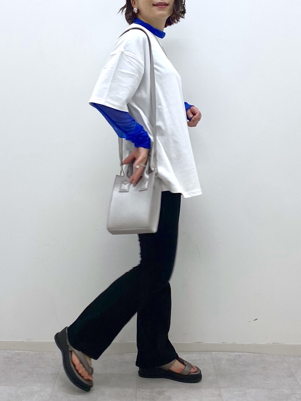 ホワイト系のTシャツ/カットソー、ブラック系のデニムパンツ、その他のサンダルを着用したレディースの夏コーディネートの3枚目の写真