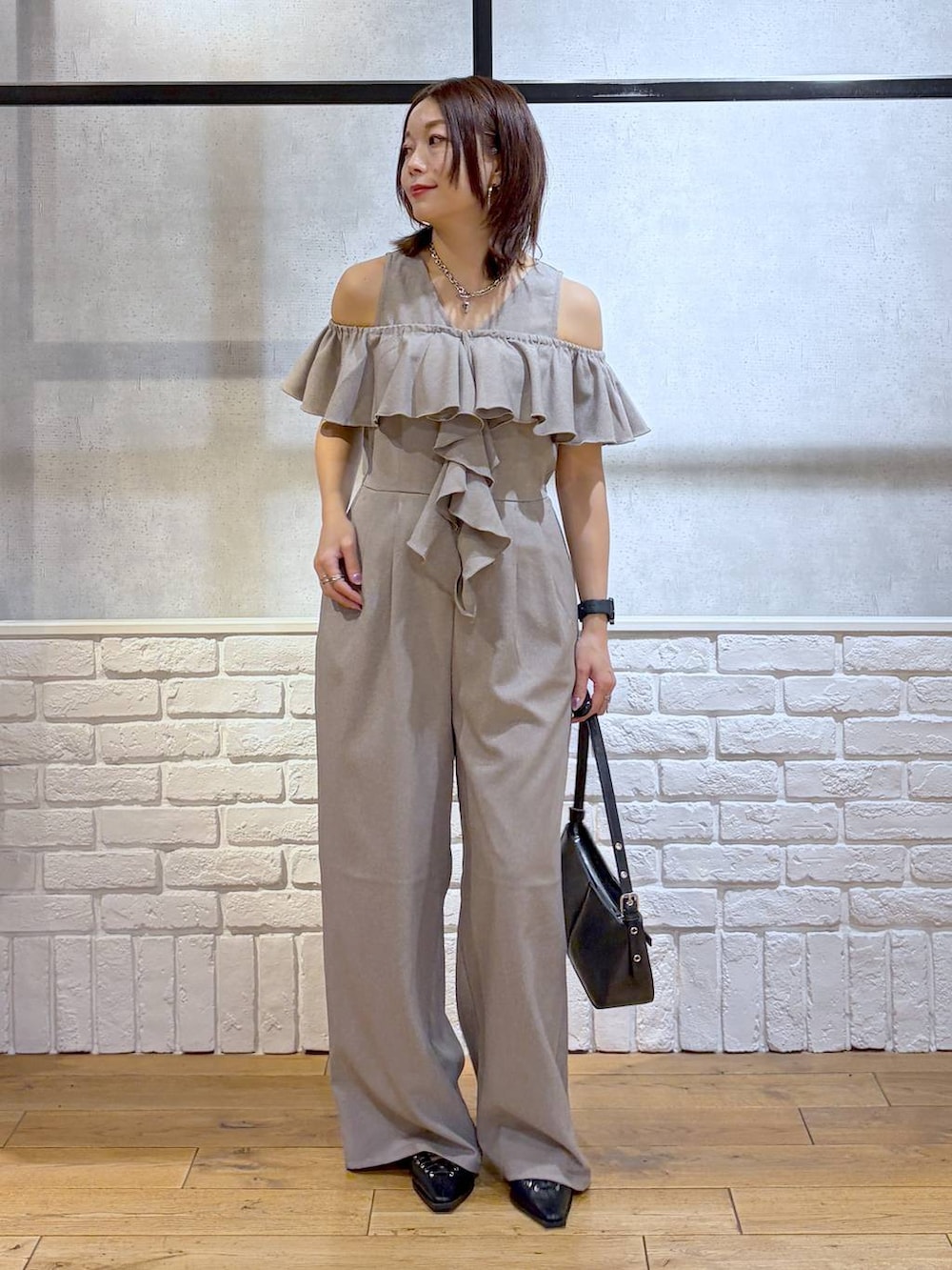 ブラック系のハンドバッグ、ブラック系のサンダル、ベージュ系のサロペット/オーバーオールを着用したレディースの春コーディネートの9枚目の写真