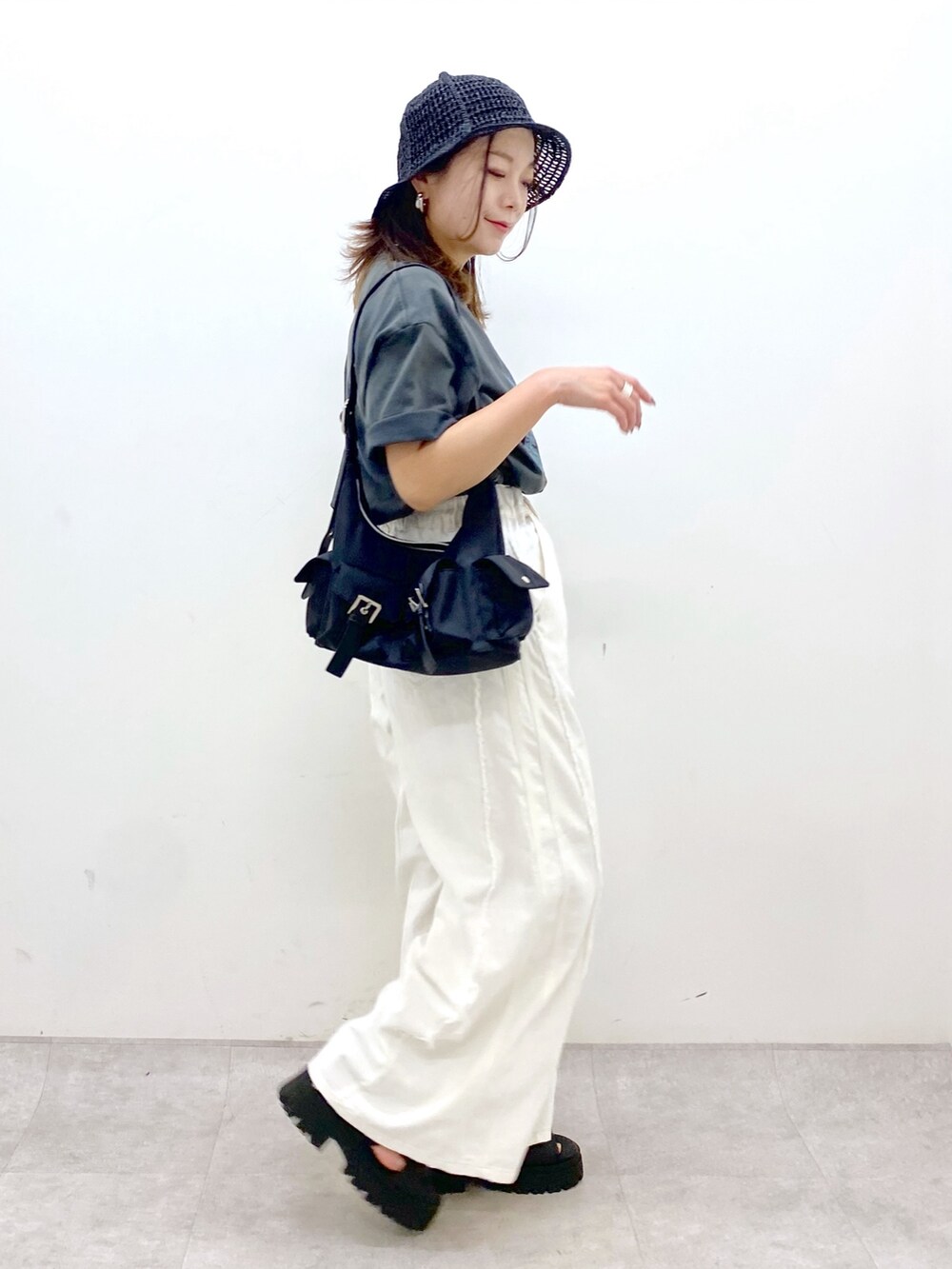 ホワイト系のデニムパンツ、ブラック系のショルダーバッグ、グレー系のTシャツ/カットソーを着用したレディースの春コーディネートの7枚目の写真