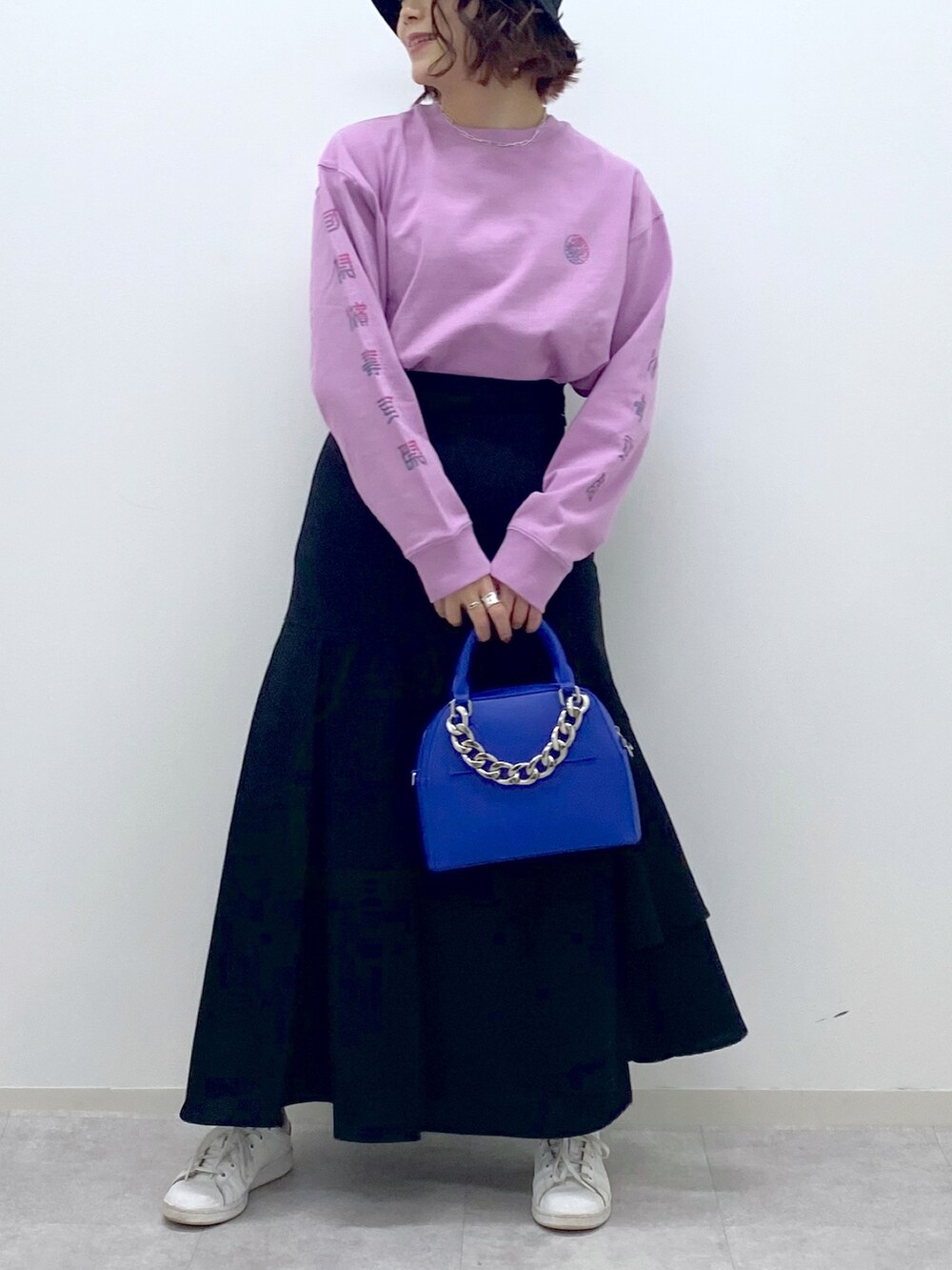 ピンク系のTシャツ/カットソー、ブラック系のスカート、ブルー系のショルダーバッグを着用したレディースの春コーディネートの5枚目の写真