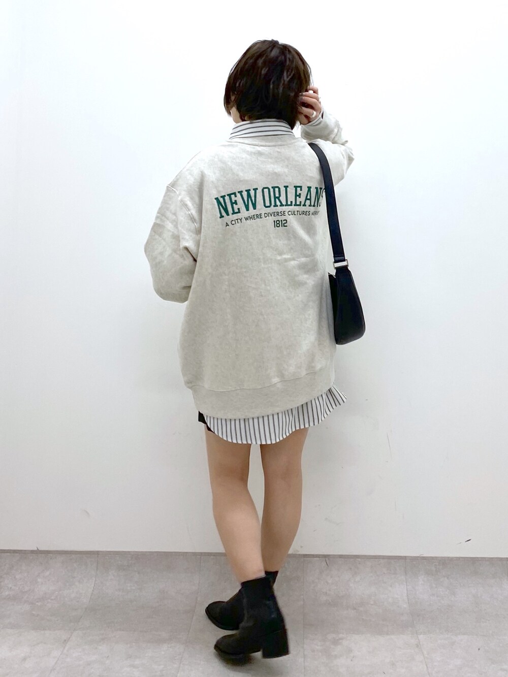 ブラック系のショルダーバッグ、ブラック系のシューズ、ベージュ系のトップスを着用したレディースの冬コーディネートの3枚目の写真