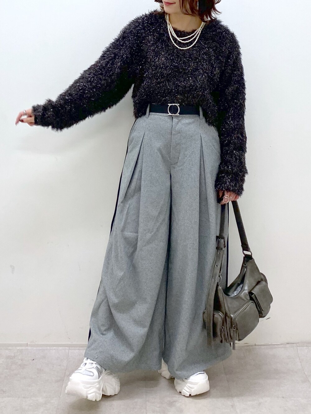 ブラック系のニット/セーター、ブラック系のスラックス、その他のショルダーバッグを着用したレディースの冬コーディネートの3枚目の写真