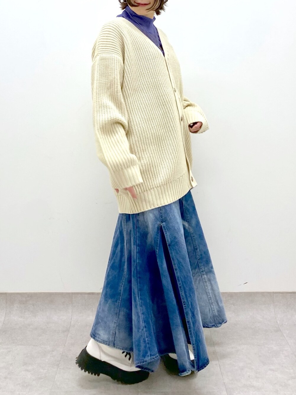 ブルー系のスカート、ホワイト系のトップス、パープル系のトップスを着用したレディースの春コーディネートの3枚目の写真