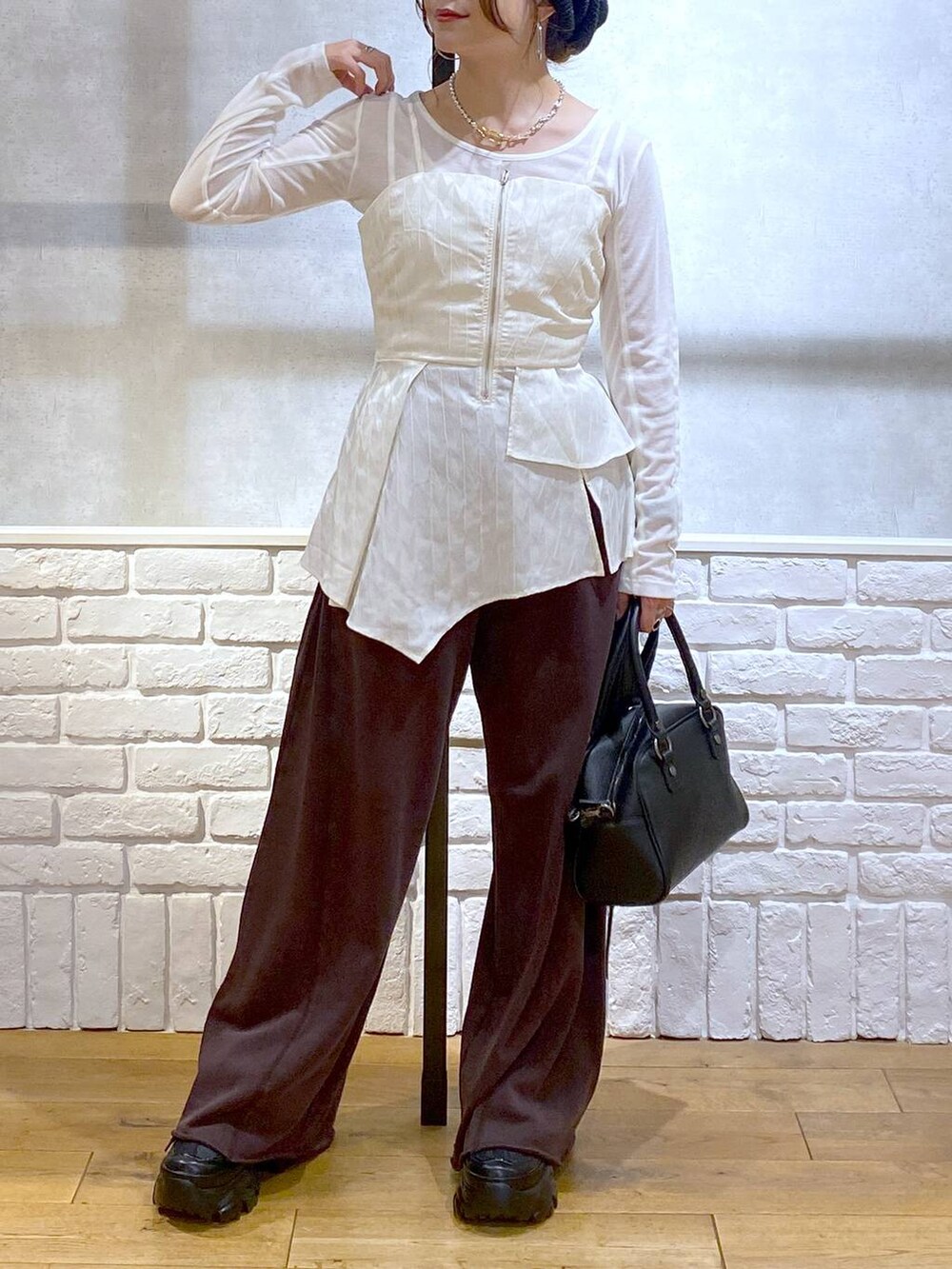 ブラック系のスニーカー、ブラック系のショルダーバッグ、ブラウン系のスウェットパンツを着用したレディースの秋コーディネートの3枚目の写真