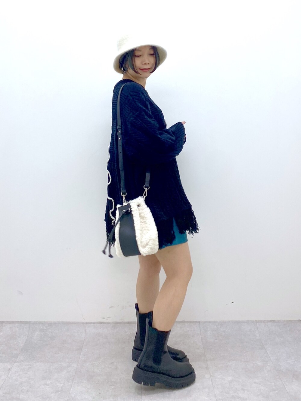 ブラック系のトップス、ブルー系のその他パンツ、ホワイト系のバッグを着用したレディースの秋コーディネートの2枚目の写真