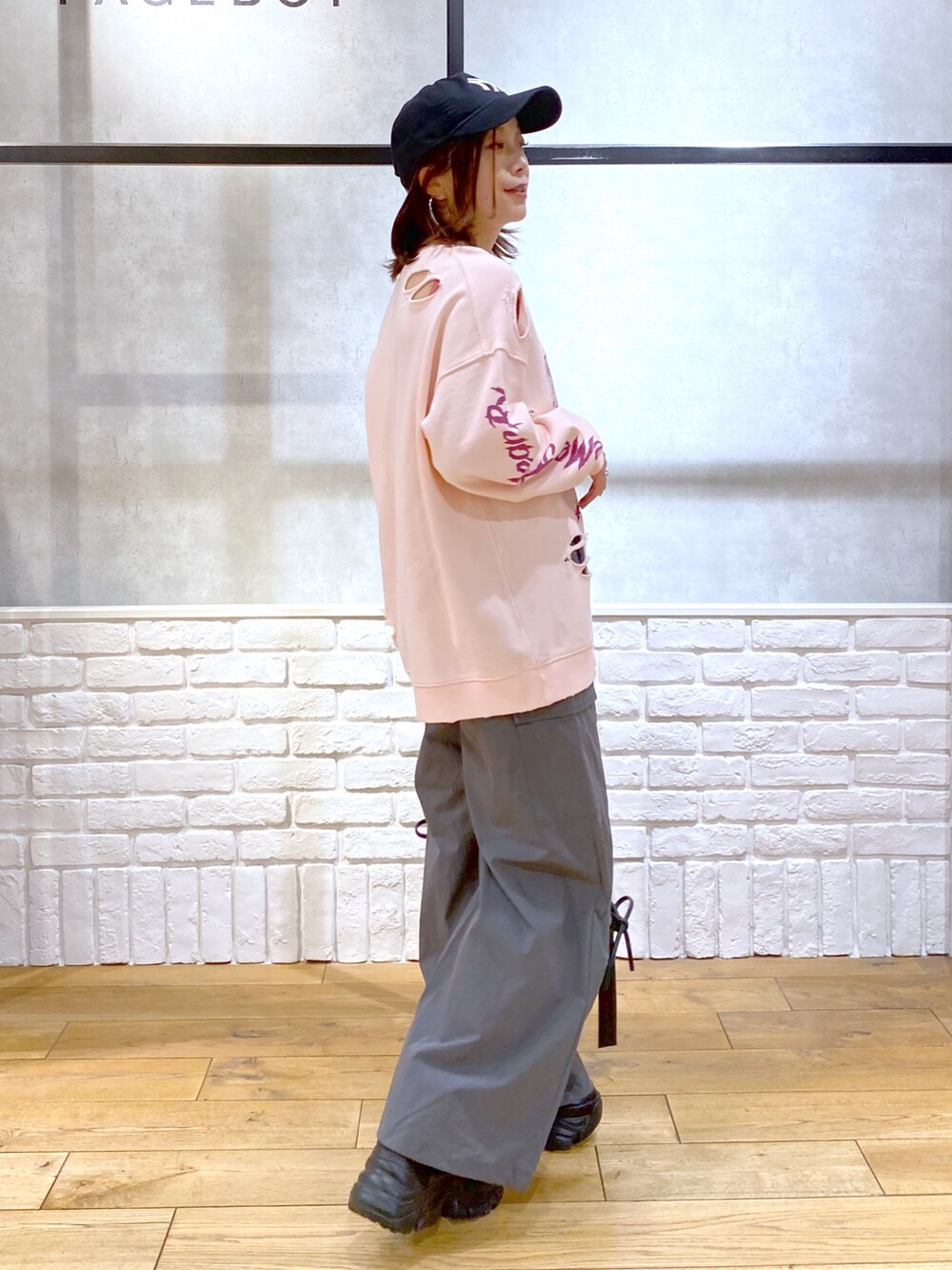 ピンク系のスウェット、グレー系のカーゴパンツ、ブラック系のショルダーバッグを着用したレディースの春コーディネートの5枚目の写真