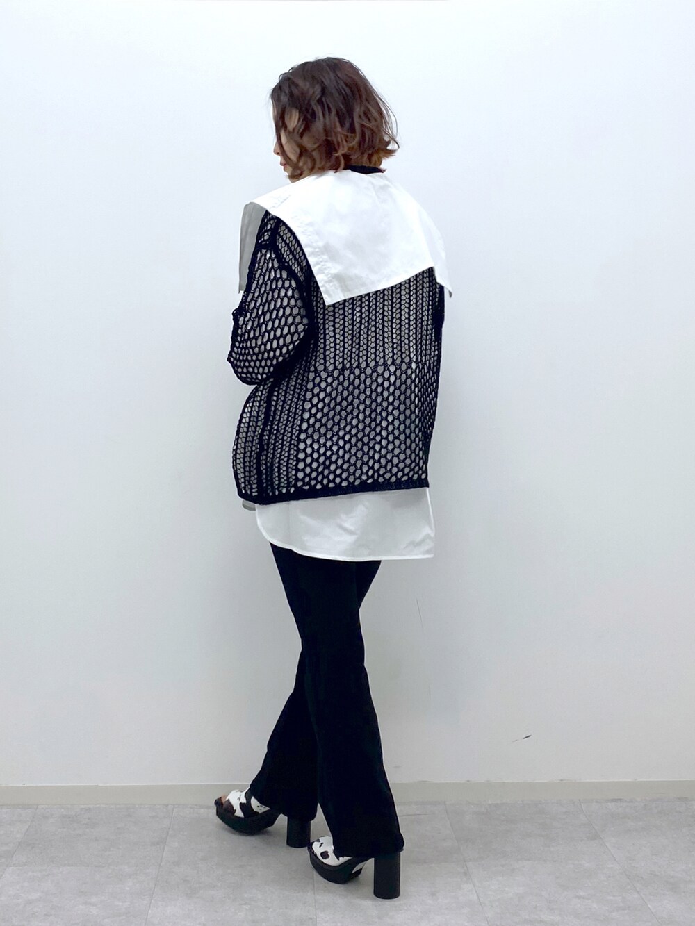 ブラック系のデニムパンツ、ホワイト系のサンダル、ホワイト系のシャツ/ブラウスを着用したレディースの春コーディネートの4枚目の写真