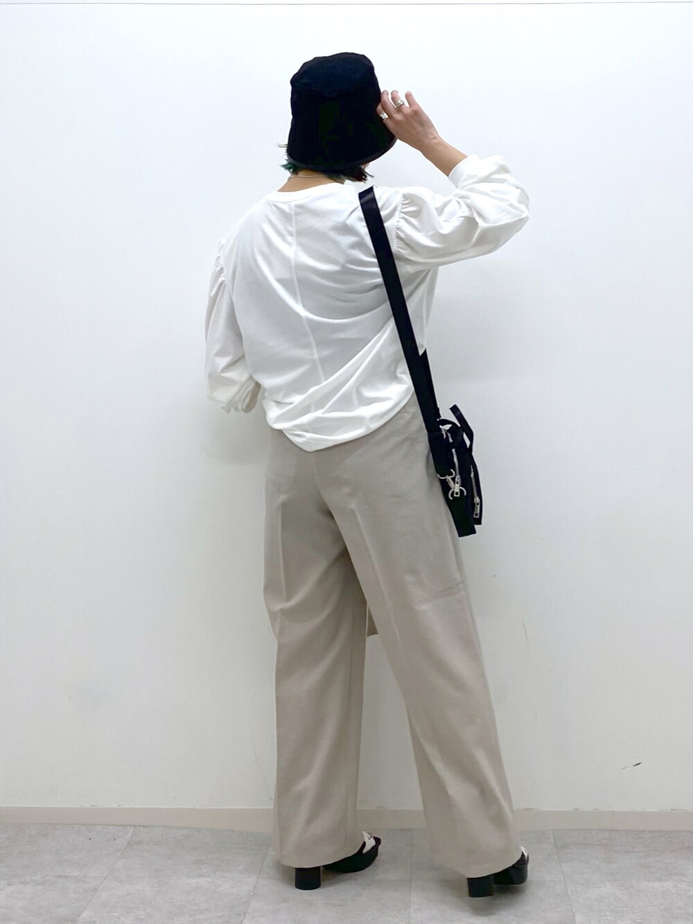 ホワイト系のTシャツ/カットソー、ベージュ系のその他パンツ、ブラック系のショルダーバッグを着用したレディースの春コーディネートの3枚目の写真