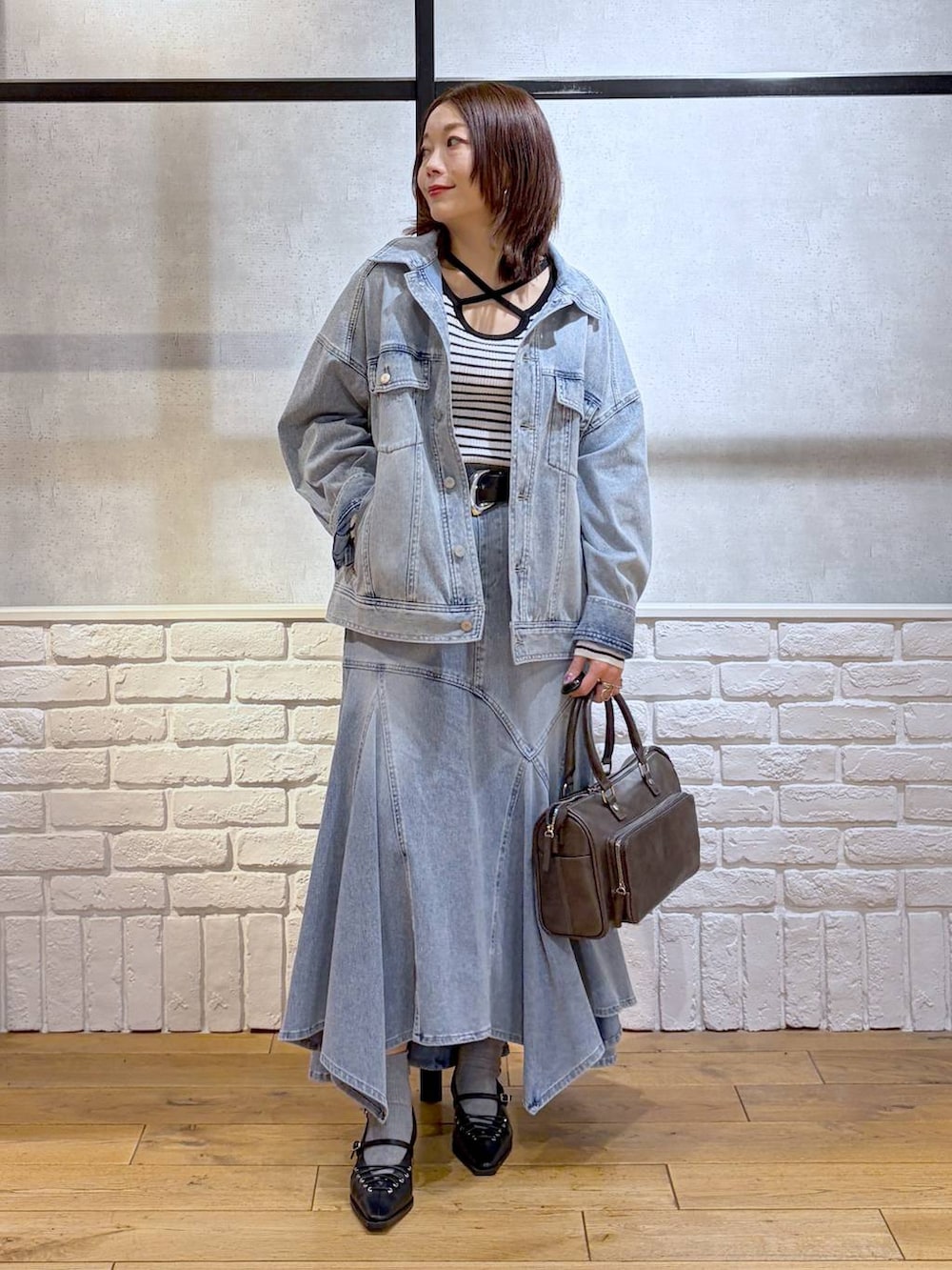 ブルー系のブルゾン、グレー系のショルダーバッグ、ホワイト系のニット/セーターを着用したレディースの春コーディネートの8枚目の写真