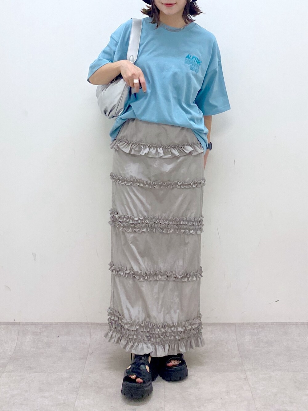 ブルー系のTシャツ/カットソー、シルバー系のショルダーバッグ、グレー系のスカートを着用したレディースの夏コーディネートの3枚目の写真