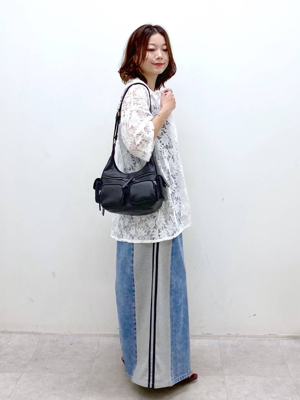 ブラック系のショルダーバッグ、レッド系のサンダル、ブルー系のスカートを着用したレディースの夏コーディネートの5枚目の写真