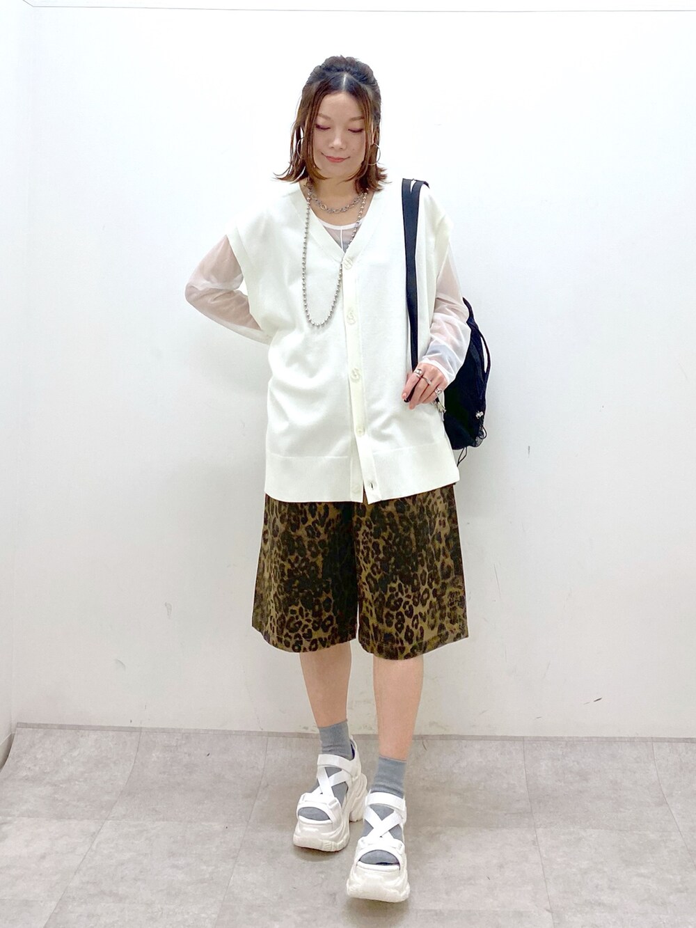 ホワイト系のカーディガン/ボレロ、ホワイト系のTシャツ/カットソー、ブラック系のバックパック/リュックを着用したレディースの春コーディネートの8枚目の写真