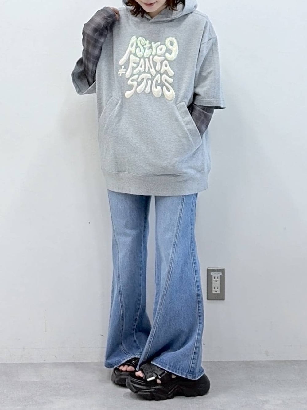 ブルー系のデニムパンツ、ブラック系のサンダル、グレー系のTシャツ/カットソーを着用したレディースの春コーディネートの4枚目の写真