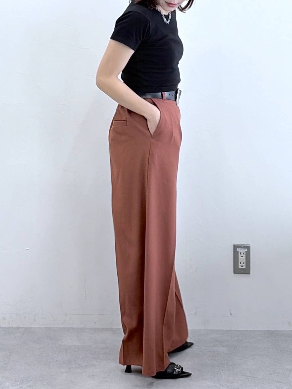 ブラウン系のスラックス、ブラック系のTシャツ/カットソー、ブラック系のキャップを着用したレディースの春コーディネートの3枚目の写真