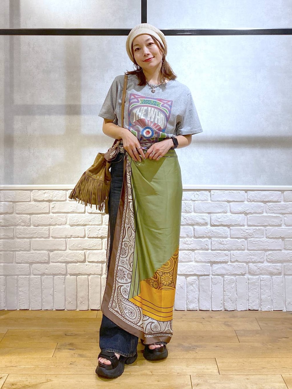 ブラック系のサンダル、ブルー系のデニムパンツ、ベージュ系のショルダーバッグを着用したレディースの夏コーディネートの4枚目の写真