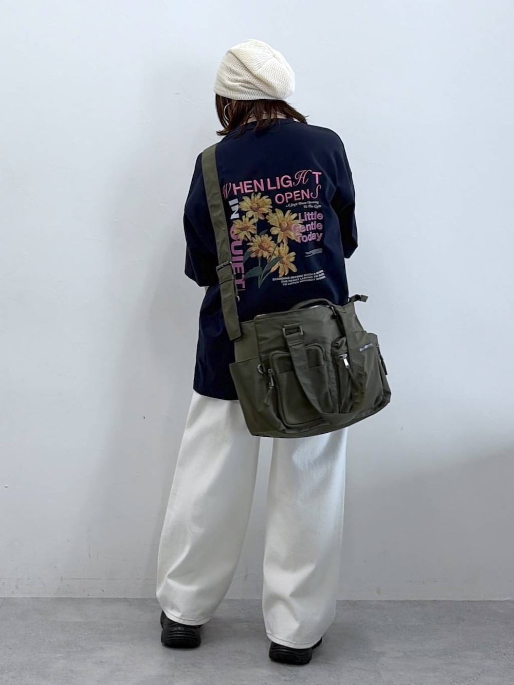 グリーン系のボストンバッグ、ホワイト系のスラックス、ブルー系のTシャツ/カットソーを着用したレディースの春コーディネートの6枚目の写真