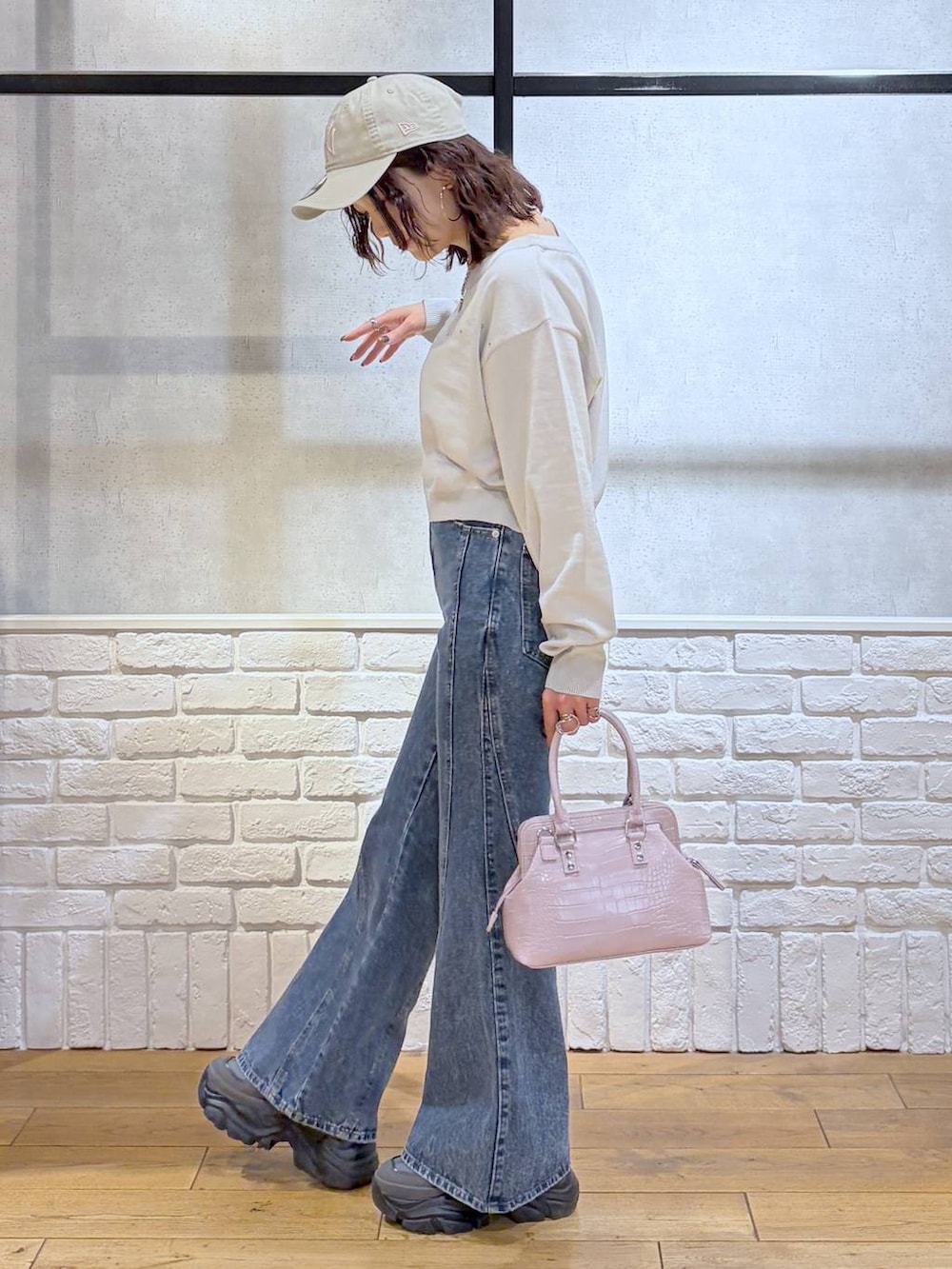 グレー系のスニーカー、ブルー系のデニムパンツ、ピンク系のハンドバッグを着用したレディースの冬コーディネートの5枚目の写真