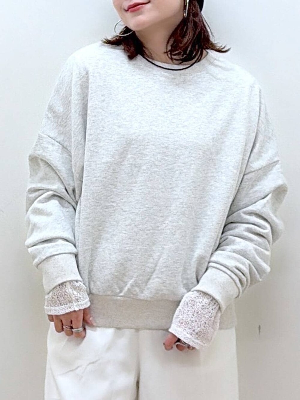 グレー系のスウェット、ホワイト系のスラックス、ホワイト系のTシャツ/カットソーを着用したレディースの冬コーディネートの2枚目の写真