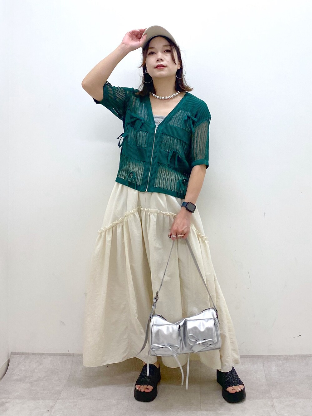 ホワイト系のスカート、グレー系のタンクトップ、シルバー系のショルダーバッグを着用したレディースの夏コーディネートの4枚目の写真