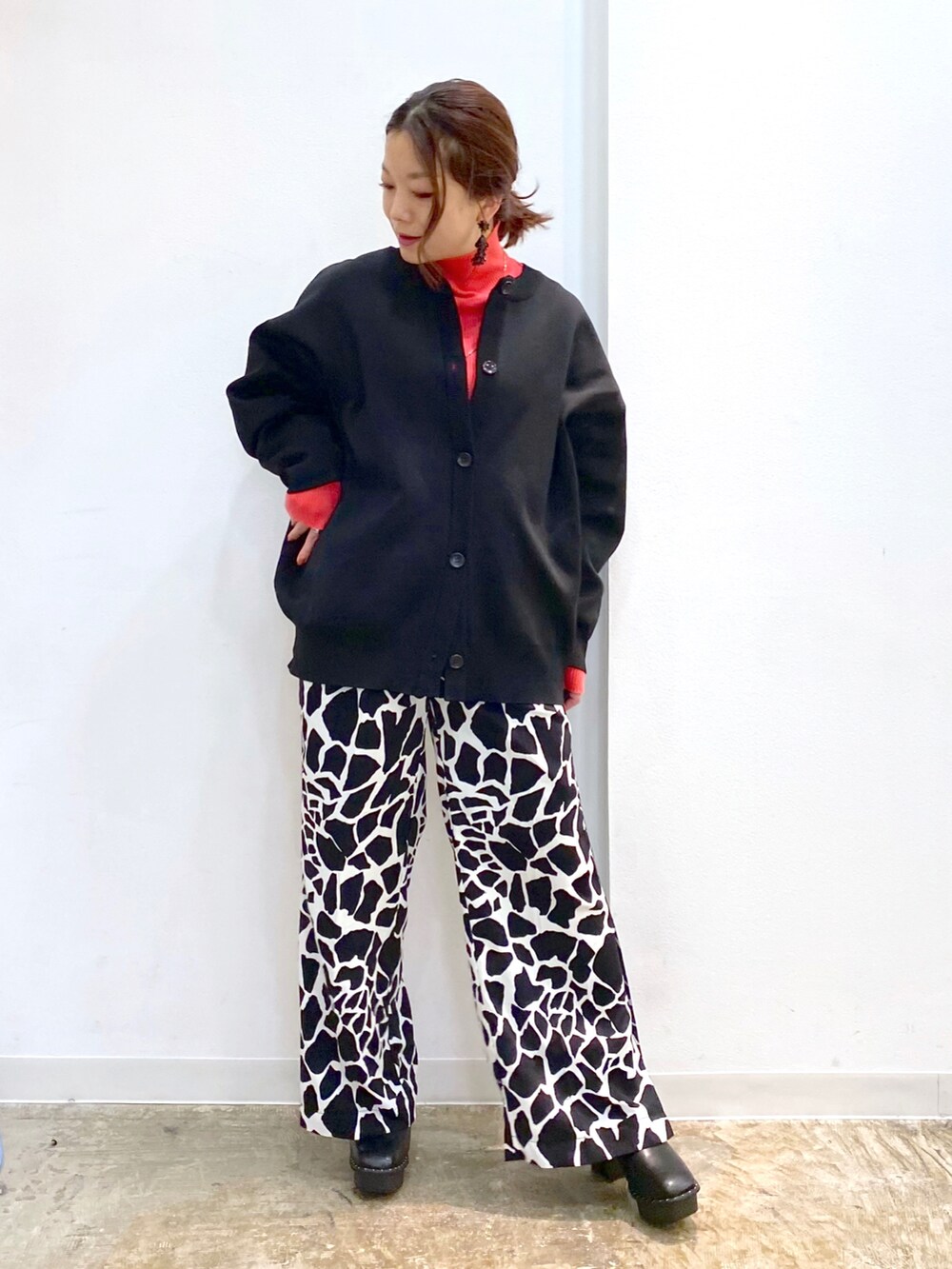 ブラック系のカーディガン/ボレロ、ピンク系のニット/セーター、ブラック系のブーツを着用したレディースの冬コーディネートの2枚目の写真