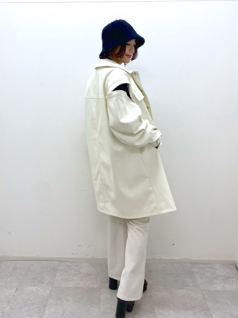 ホワイト系のジャケット/アウター、ブラック系のトップス、ホワイト系のパンツを着用したレディースの秋コーディネートの5枚目の写真