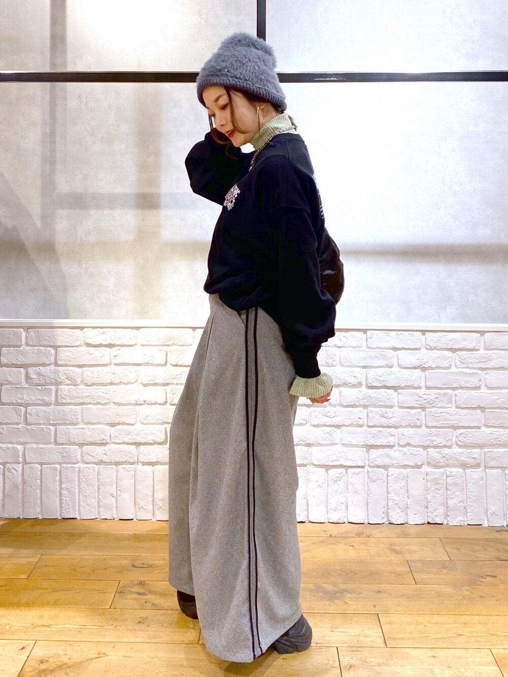 ブラック系のスウェット、グリーン系のショルダーバッグ、ブラック系のスラックスを着用したレディースの秋コーディネートの7枚目の写真