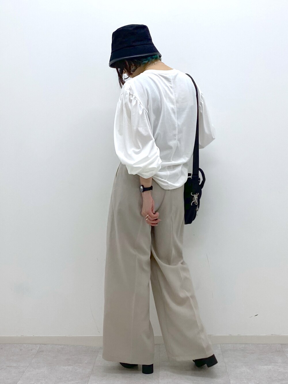 ホワイト系のTシャツ/カットソー、ベージュ系のその他パンツ、ブラック系のショルダーバッグを着用したレディースの春コーディネートの4枚目の写真