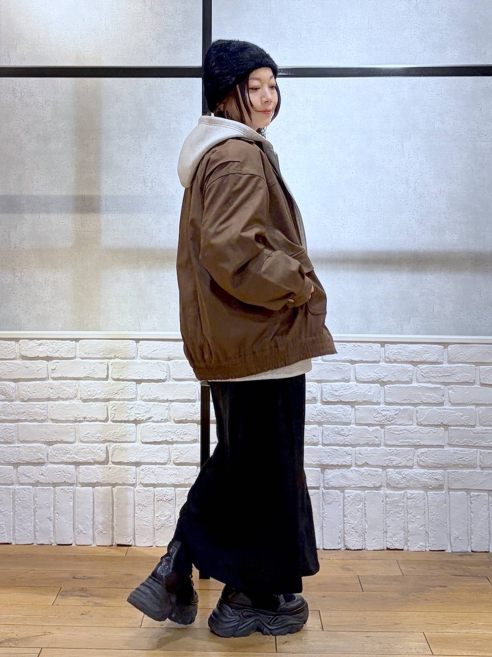 ブラック系のブーツ、ブラウン系のブルゾン、レッド系のニット/セーターを着用したレディースの冬コーディネートの7枚目の写真