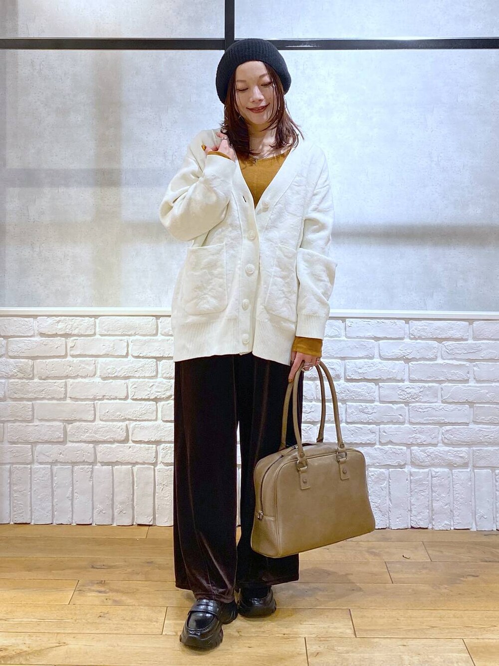 ベージュ系のボストンバッグ、イエロー系のTシャツ/カットソー、ブラック系のローファーを着用したレディースの冬コーディネートの4枚目の写真