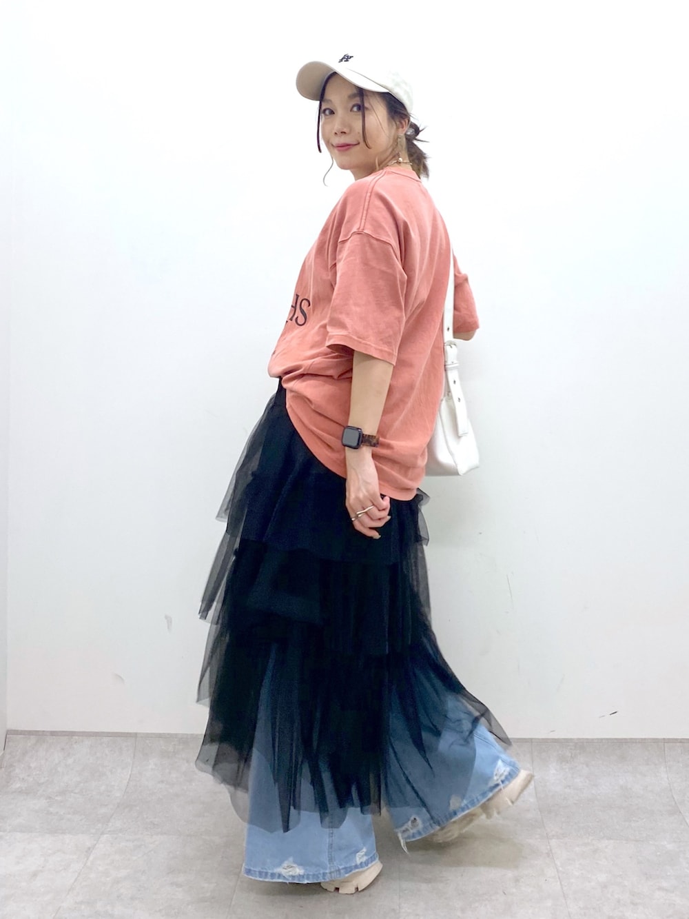 ブルー系のデニムパンツ、オレンジ系のTシャツ/カットソー、ブラック系のスカートを着用したレディースの夏コーディネートの5枚目の写真