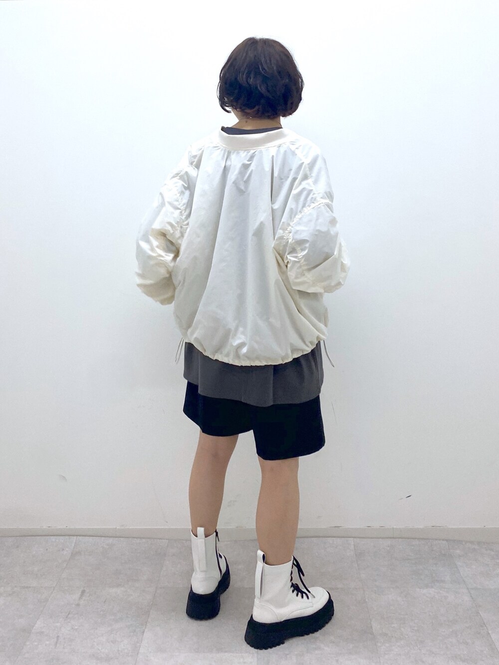 グレー系のTシャツ/カットソー、ブラック系のパンツ、ホワイト系のジャケット/アウターを着用したレディースの秋コーディネートの3枚目の写真