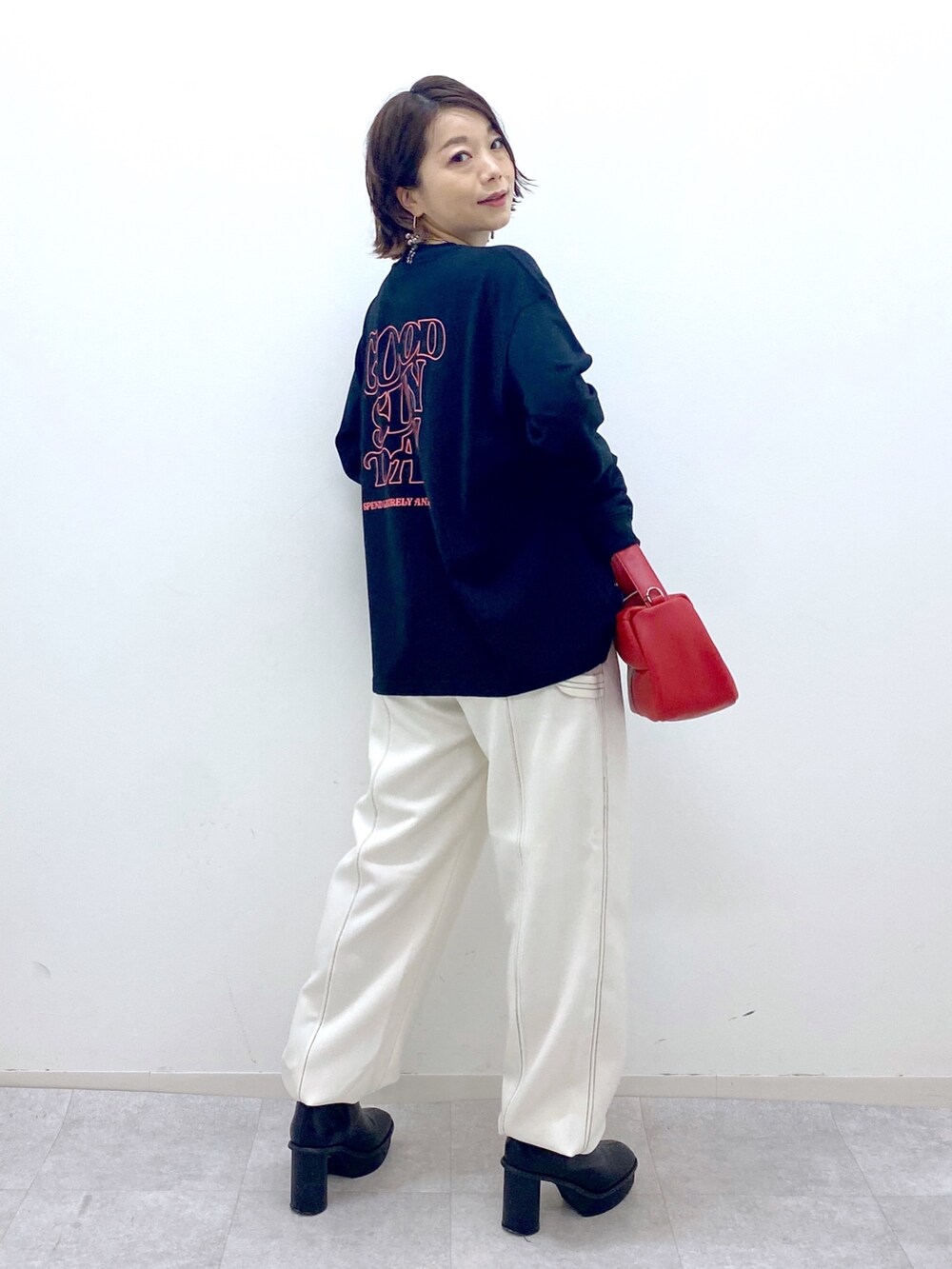 ブラック系のTシャツ/カットソー、ホワイト系のその他パンツ、ブラック系のブーツを着用したレディースの秋コーディネートの3枚目の写真