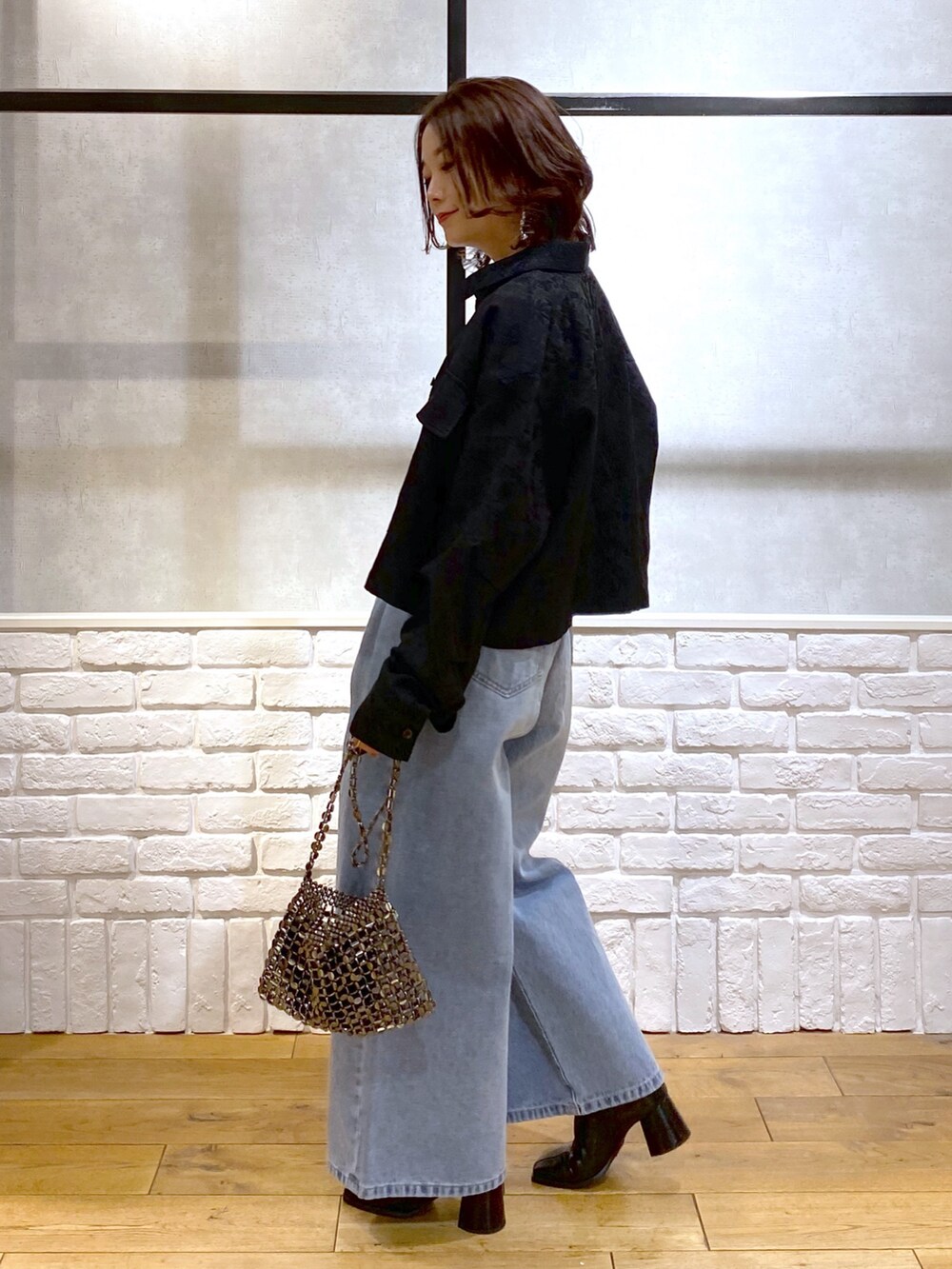 ブラック系のシャツ/ブラウス、ブルー系のデニムパンツ、ブルー系のショルダーバッグを着用したレディースの冬コーディネートの5枚目の写真