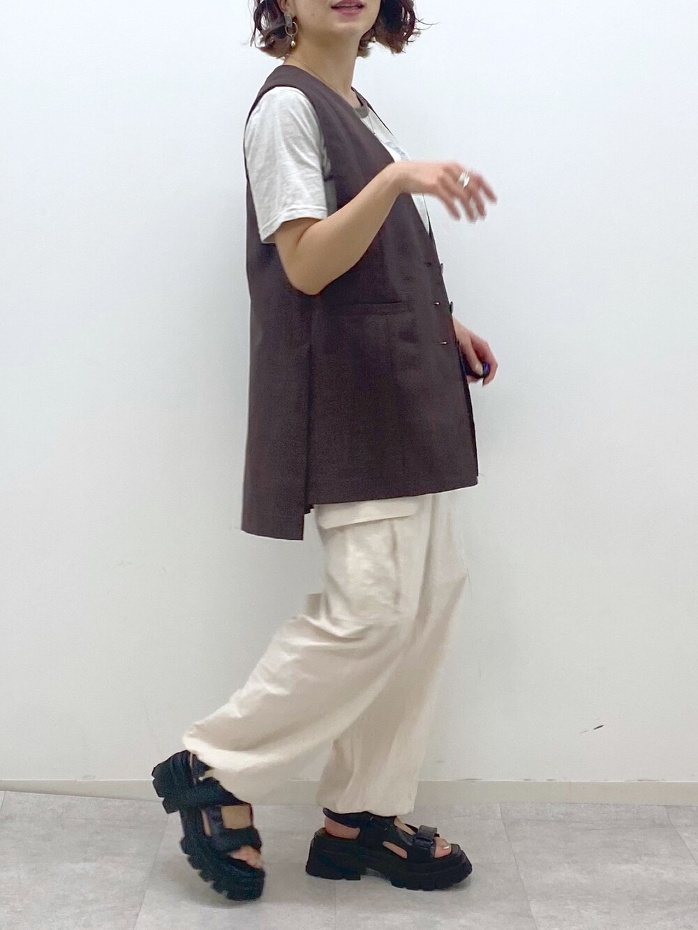 ホワイト系のカーゴパンツ、ブラック系のサンダル、ベージュ系のTシャツ/カットソーを着用したレディースの夏コーディネートの4枚目の写真