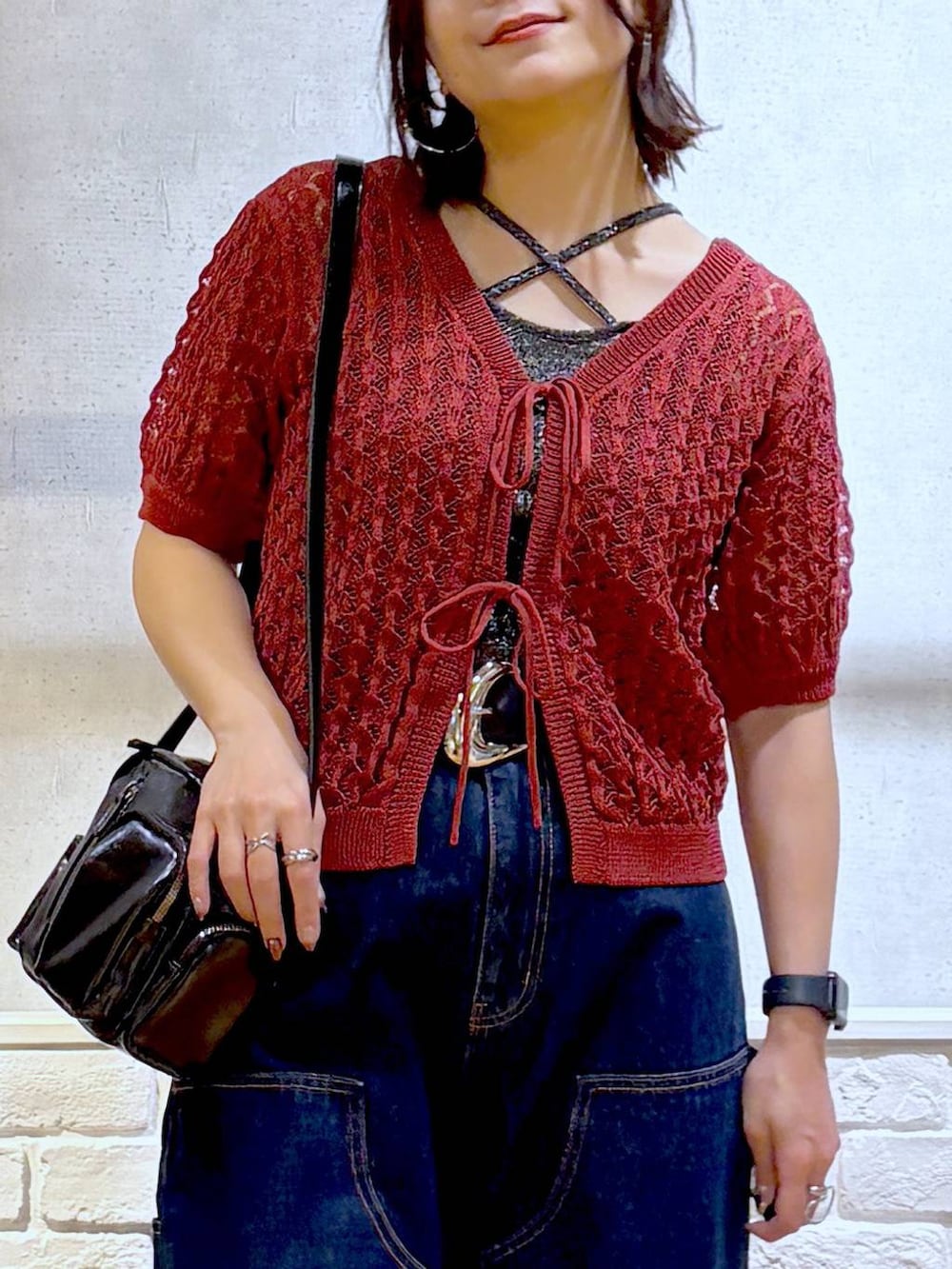 ブルー系のデニムパンツ、ブラック系のショルダーバッグ、ブラック系のサンダルを着用したレディースの夏コーディネートの2枚目の写真