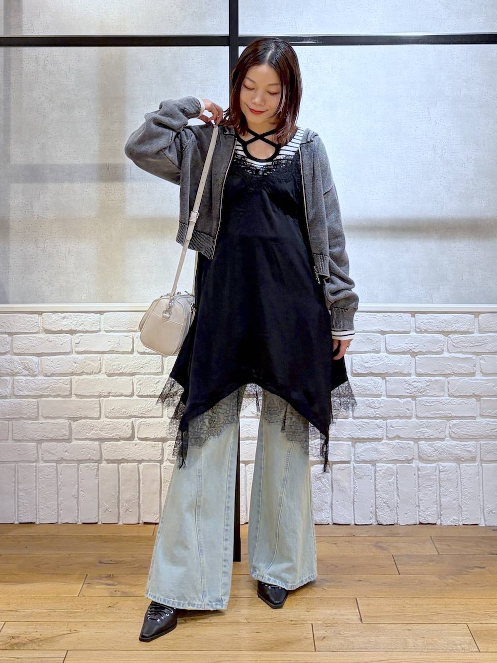 ブルー系のデニムパンツ、ホワイト系のボストンバッグ、ホワイト系のニット/セーターを着用したレディースの春コーディネートの8枚目の写真