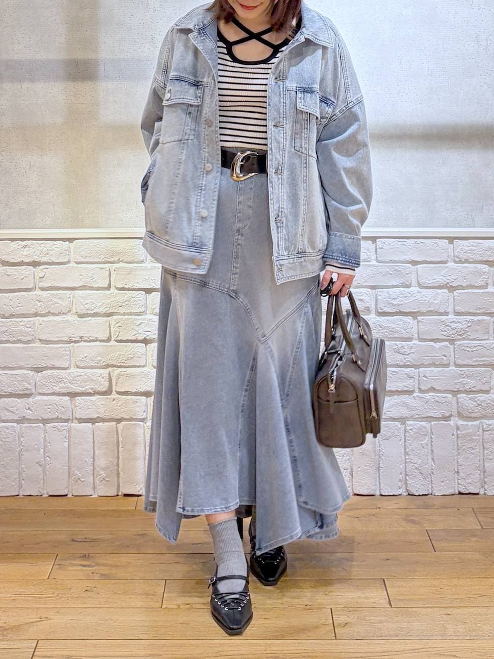 ブルー系のブルゾン、グレー系のショルダーバッグ、ホワイト系のニット/セーターを着用したレディースの春コーディネートの3枚目の写真