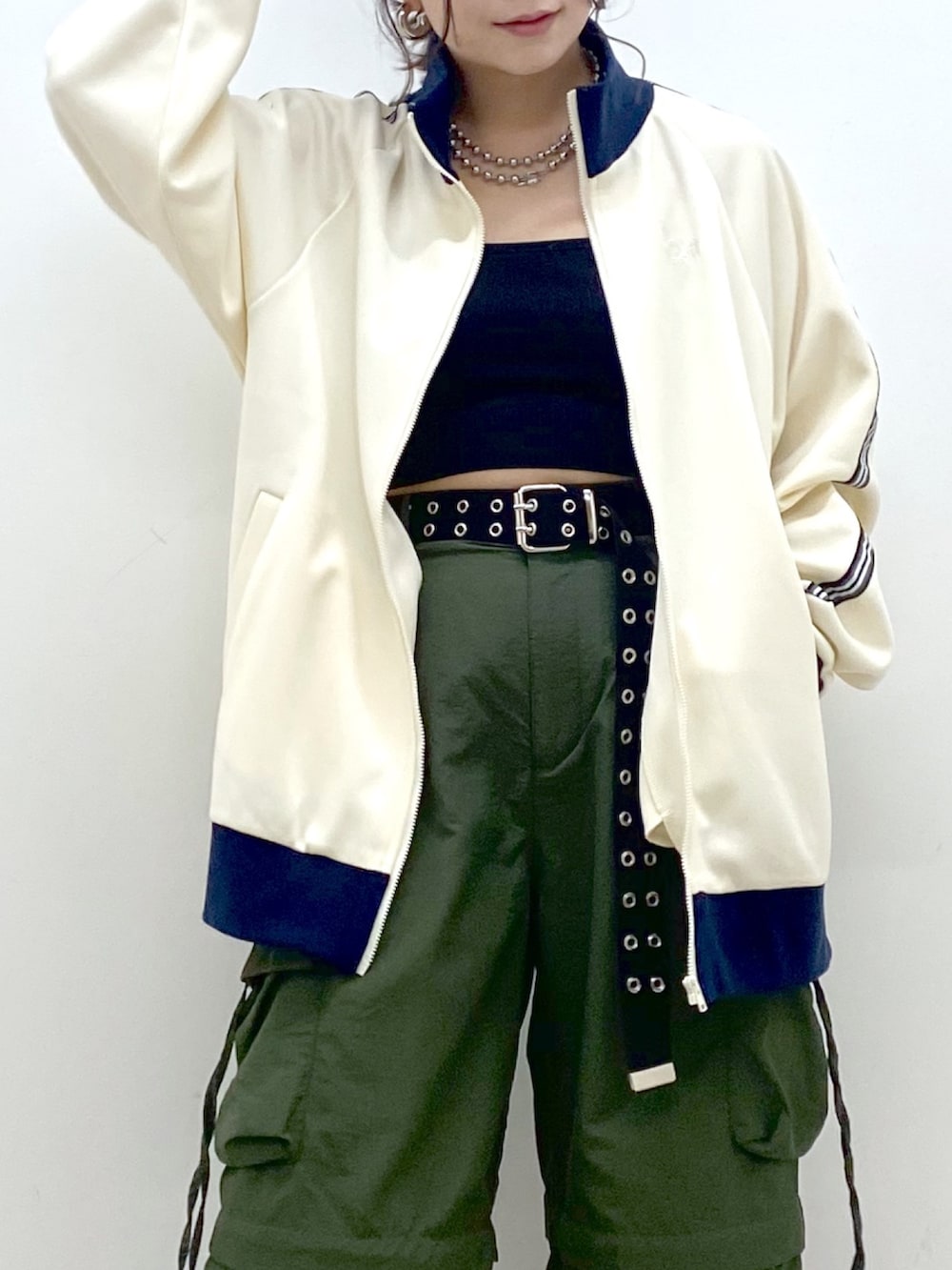 ブラック系のキャミソール、ホワイト系のセットアップ、グリーン系のカーゴパンツを着用したレディースの冬コーディネートの2枚目の写真