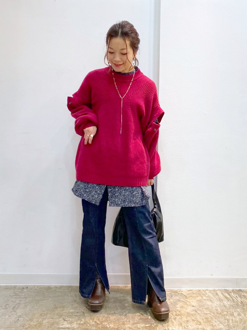 ピンク系のニット/セーター、ブラック系のTシャツ/カットソー、ブラック系のハンドバッグを着用したレディースの秋コーディネートの4枚目の写真