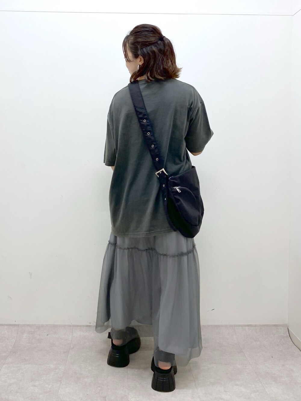 グレー系のTシャツ/カットソー、グレー系のスカート、ブラック系のスニーカーを着用したレディースの夏コーディネートの5枚目の写真