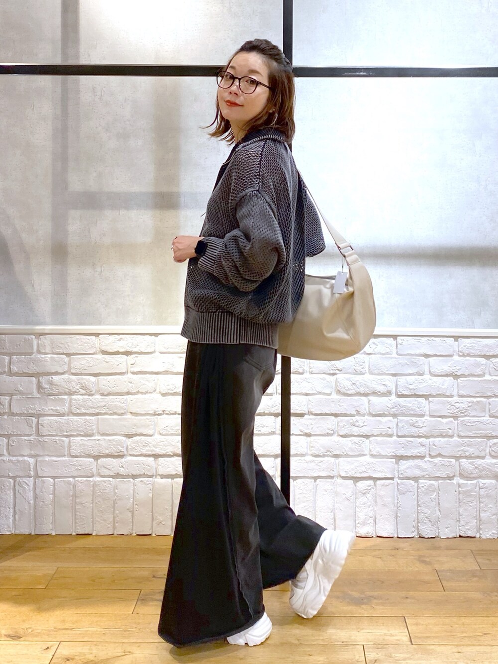 ピンク系のキャミソール、ブラック系のニット/セーター、ブラック系のデニムパンツを着用したレディースの春コーディネートの7枚目の写真