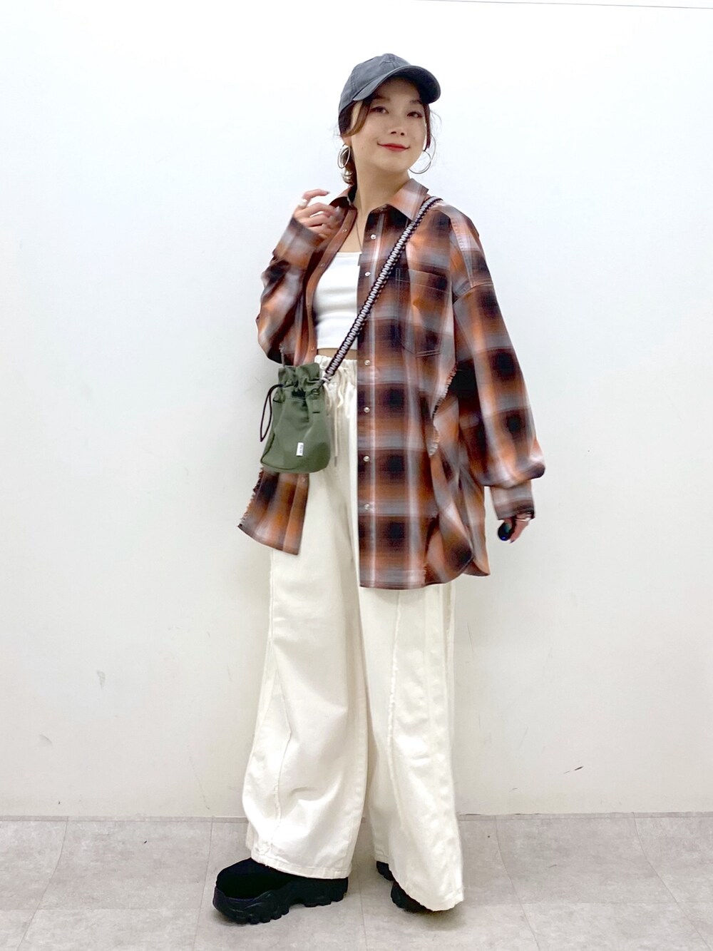 ホワイト系のデニムパンツ、ブラック系のスニーカー、グリーン系のショルダーバッグを着用したレディースの夏コーディネートの8枚目の写真