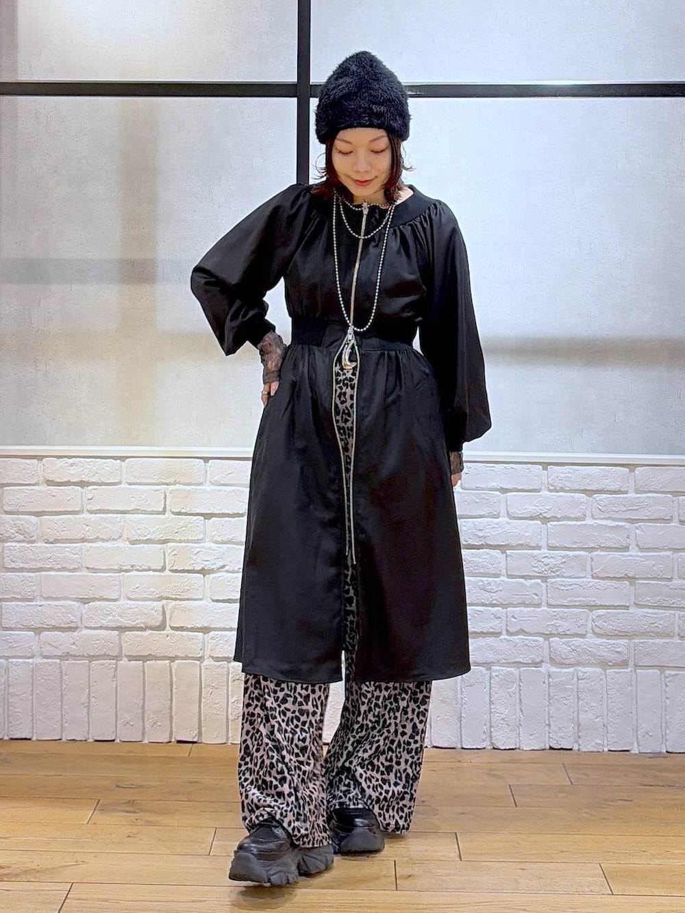 ブラック系のブーツ、ベージュ系のその他パンツ、ブラック系のワンピースを着用したレディースの冬コーディネートの8枚目の写真