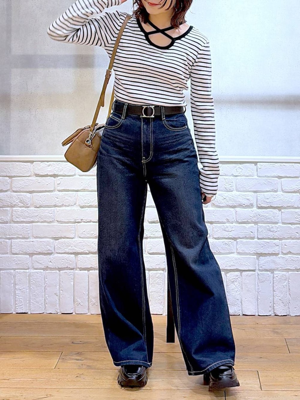 ブラック系のローファー、ブルー系のスラックス、ブラウン系のボストンバッグを着用したレディースの冬コーディネートの4枚目の写真