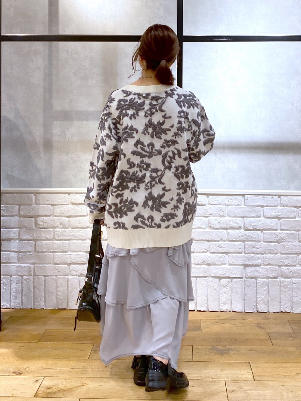 ブラック系のショルダーバッグ、ホワイト系のカーディガン/ボレロ、ホワイト系のキャミソールを着用したレディースの春コーディネートの7枚目の写真