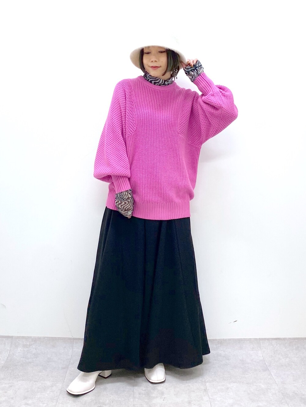 ピンク系のニット/セーター、ブラック系のスラックス、ブラック系のトップスを着用したレディースの冬コーディネートの2枚目の写真