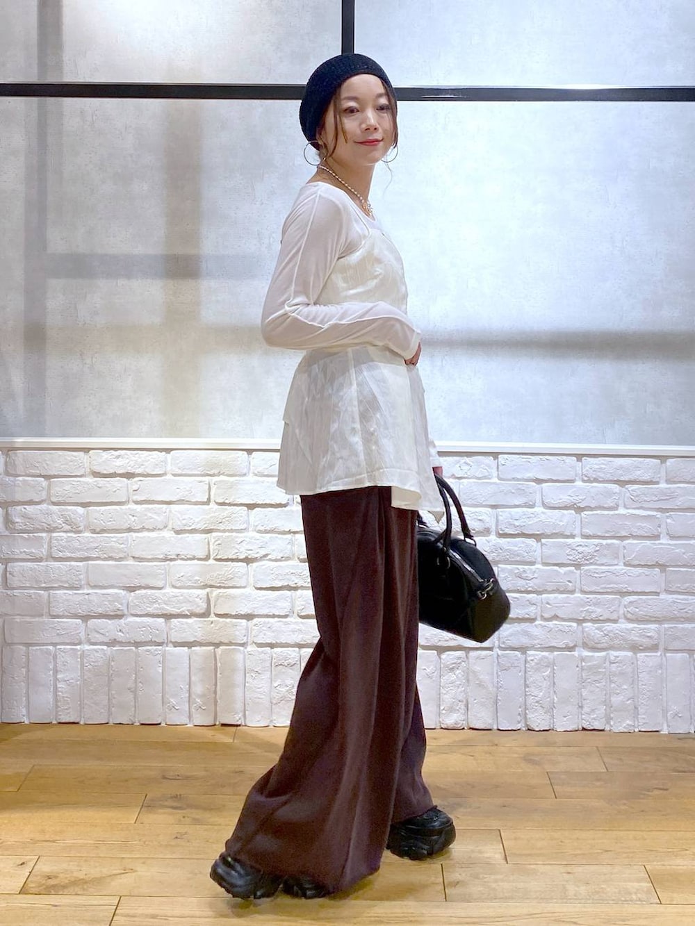 ブラック系のスニーカー、ブラック系のショルダーバッグ、ブラウン系のスウェットパンツを着用したレディースの秋コーディネートの5枚目の写真