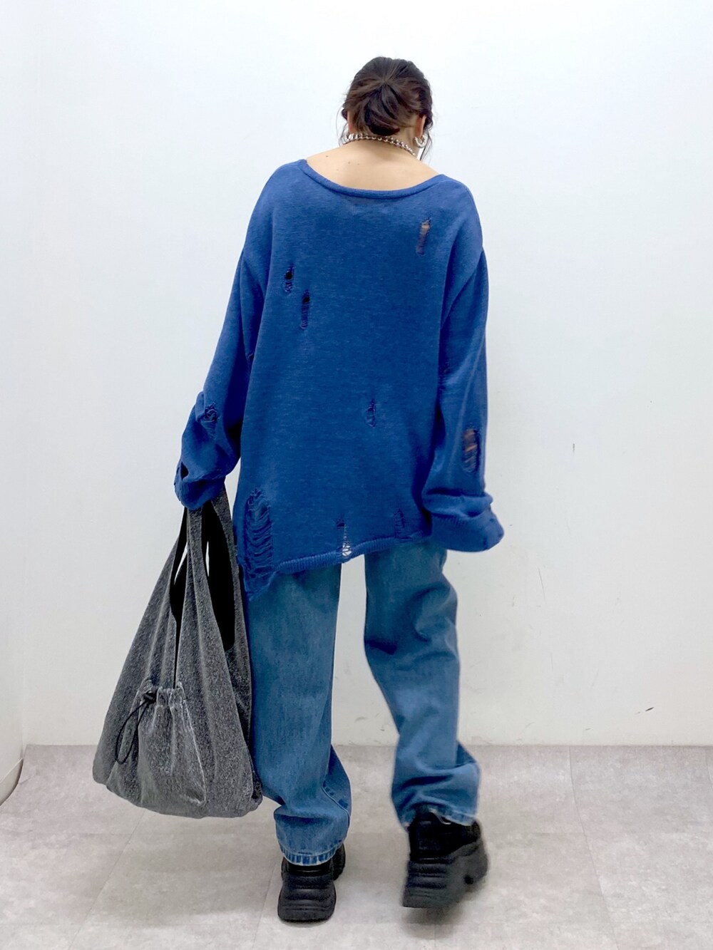 ブルー系のニット/セーター、ブルー系のデニムパンツ、ブラック系のトートバッグを着用したレディースの冬コーディネートの6枚目の写真