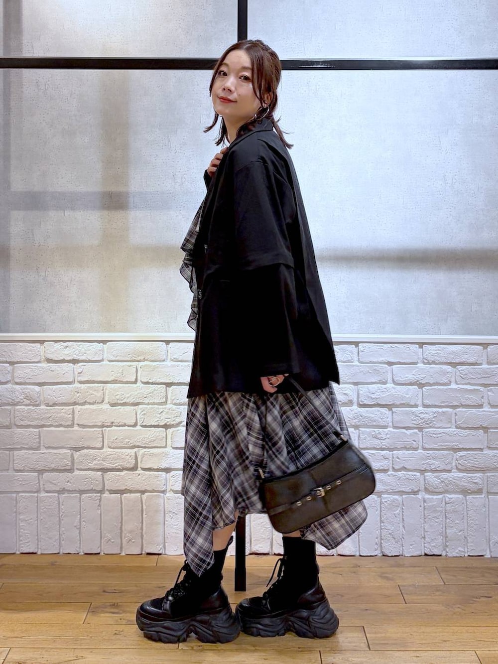 ブラック系のブーツ、ブラック系のハンドバッグ、ブラック系のテーラードジャケットを着用したレディースの春コーディネートの7枚目の写真