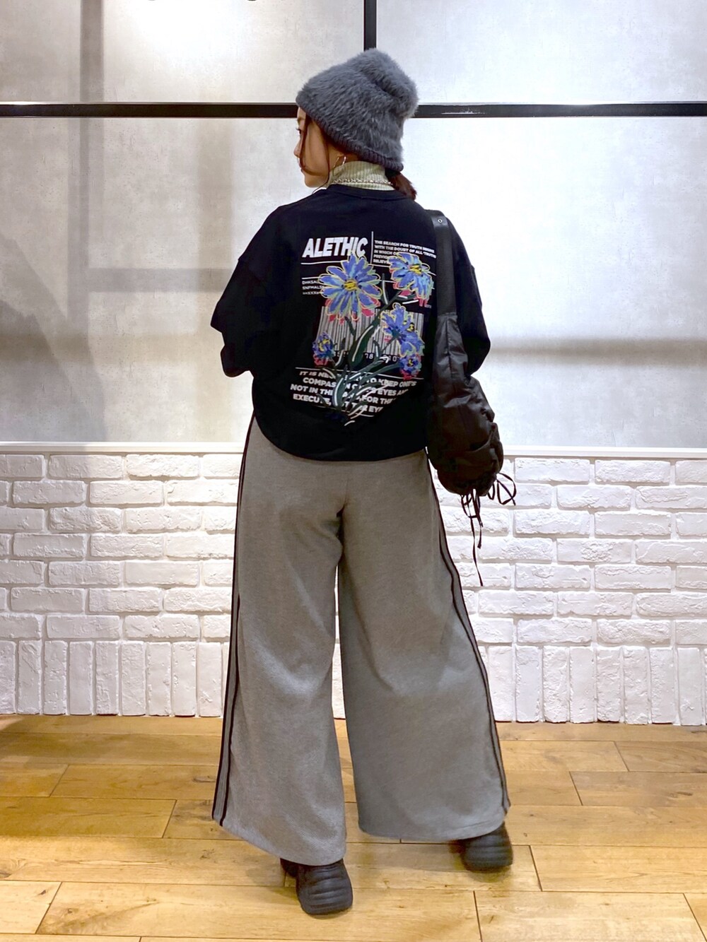 ブラック系のスウェット、グリーン系のショルダーバッグ、ブラック系のスラックスを着用したレディースの秋コーディネートの6枚目の写真